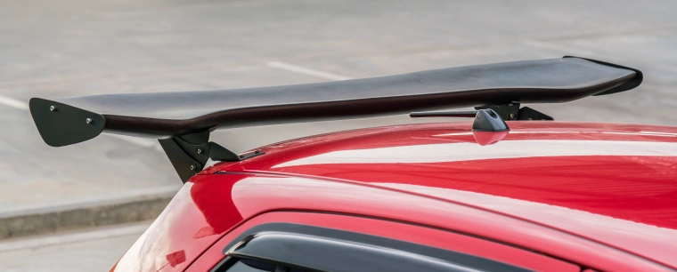 Large black spoiler attached to the back of a red car
