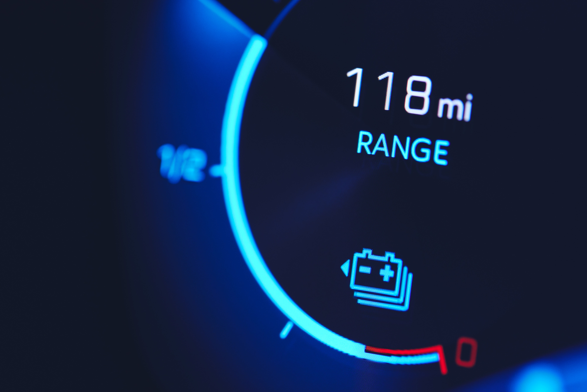 A close up picture of the range gauge in an electric car, showing that there are 118 miles left.