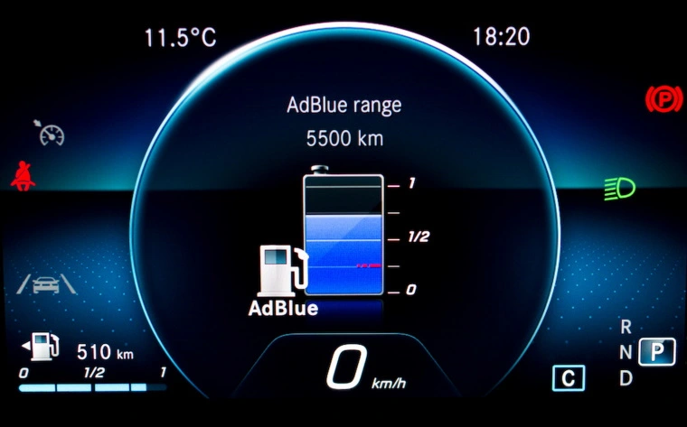 Illuminated car dashboard shows AdBlue levels — the tank is three quarters full.