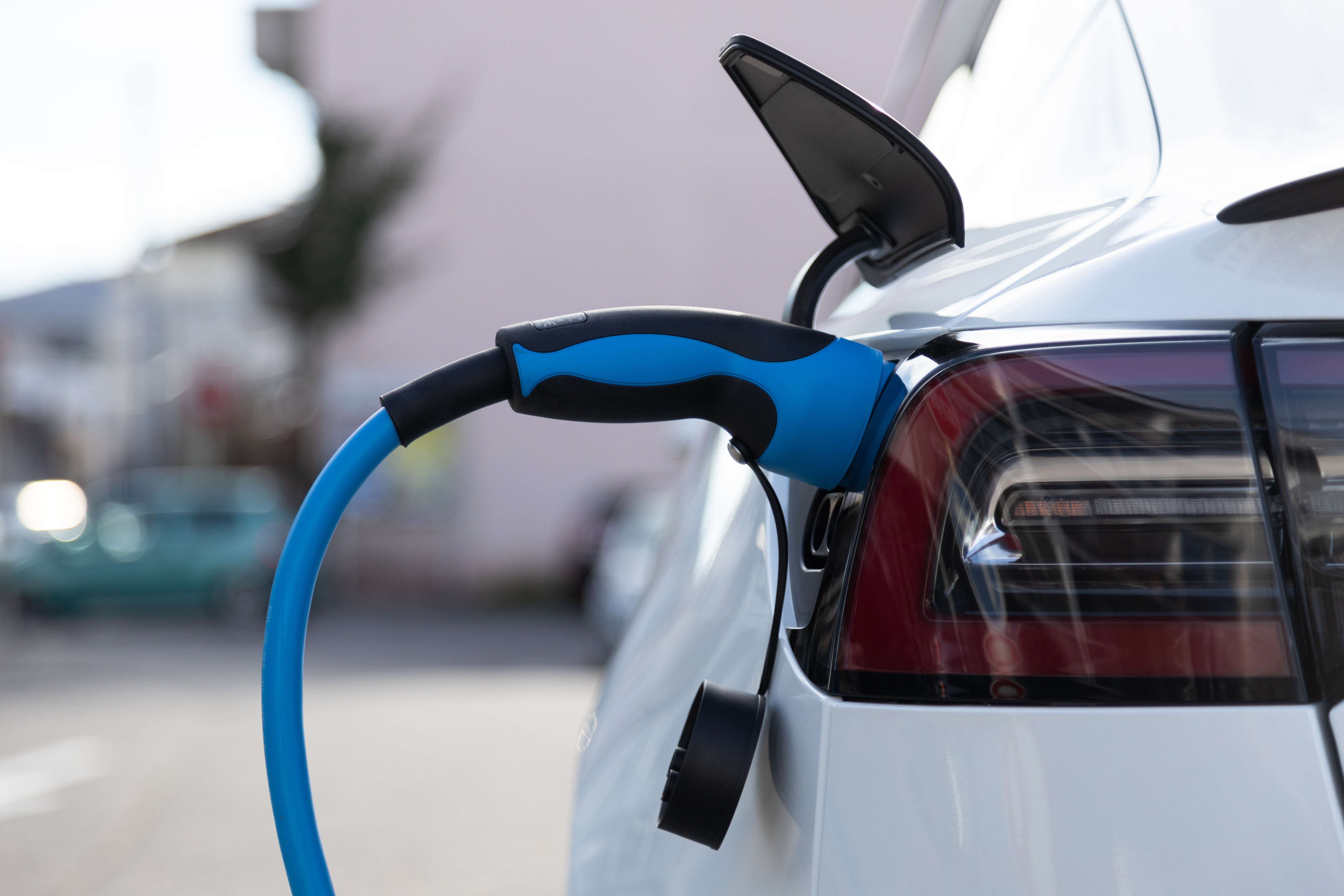 White electric car charging in a car park.