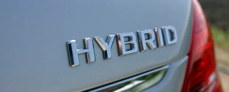 Hybrid logo on the rear of a grey car.