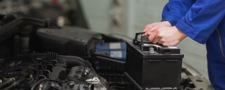 Technician fittings a new car battery