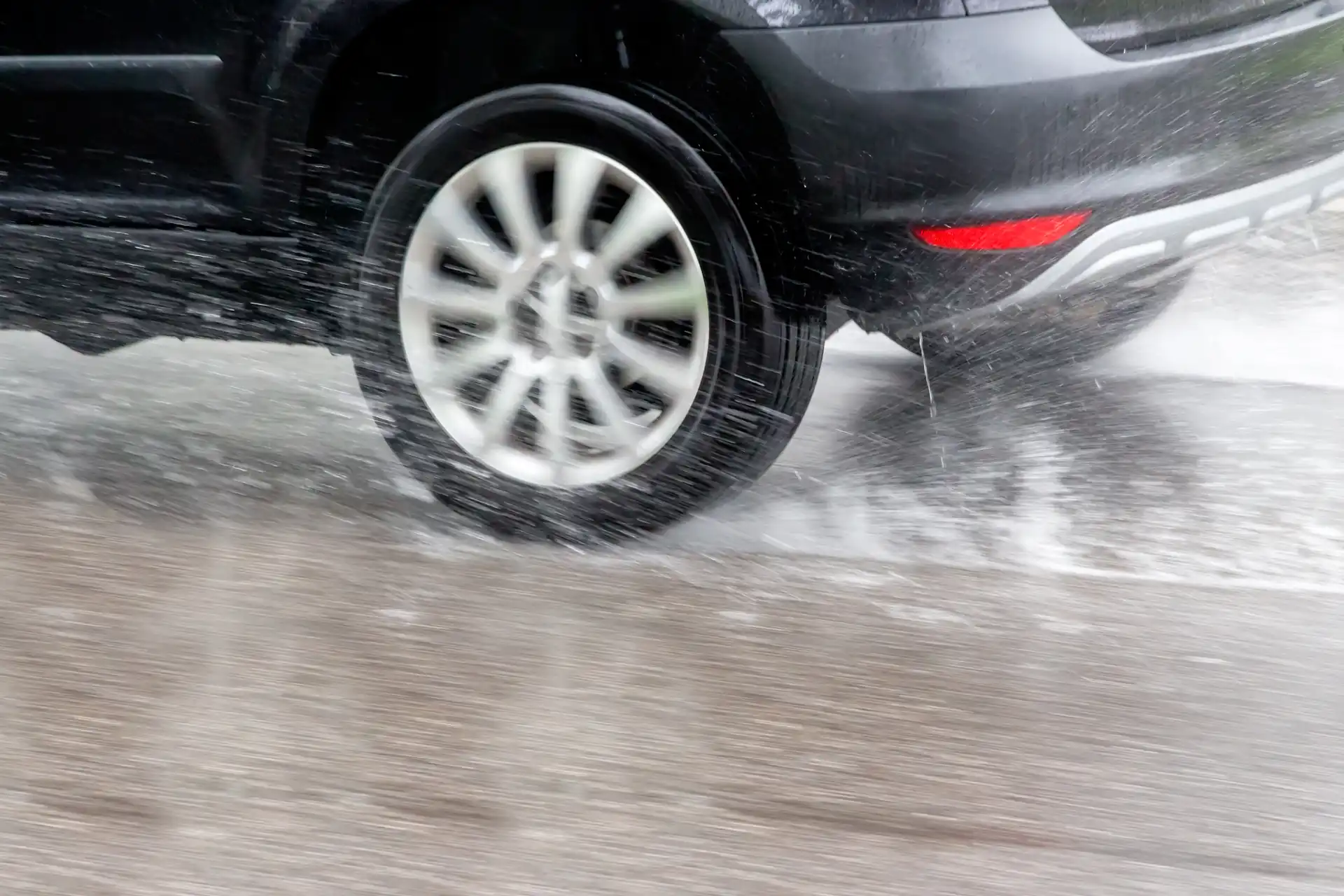 car driving through big puddles with spray