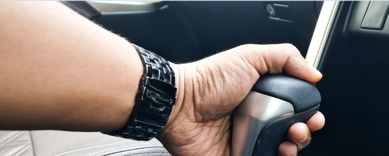 Person grabbing the gear stick with their left hand.