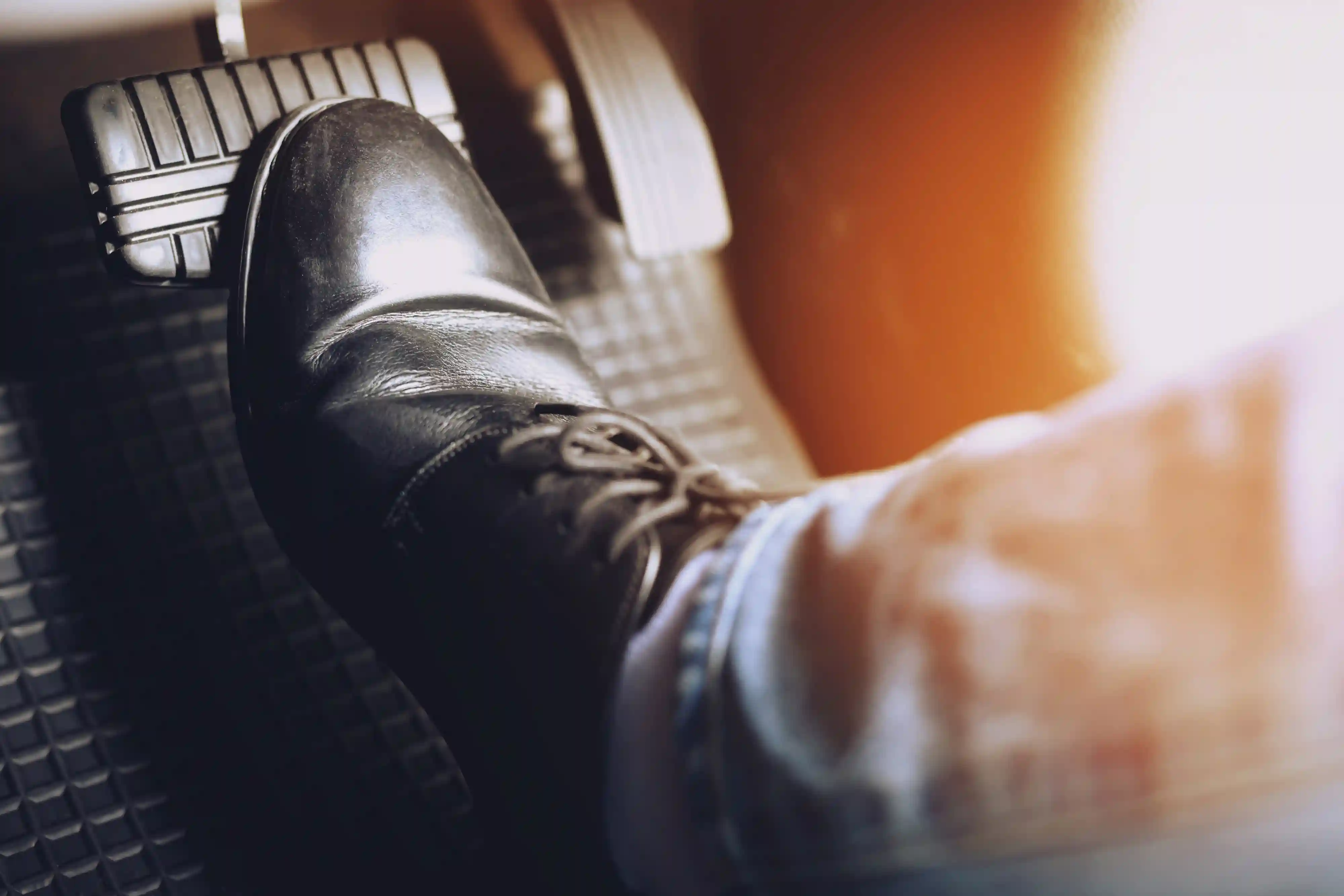 A person pressing down on the brake pedal.