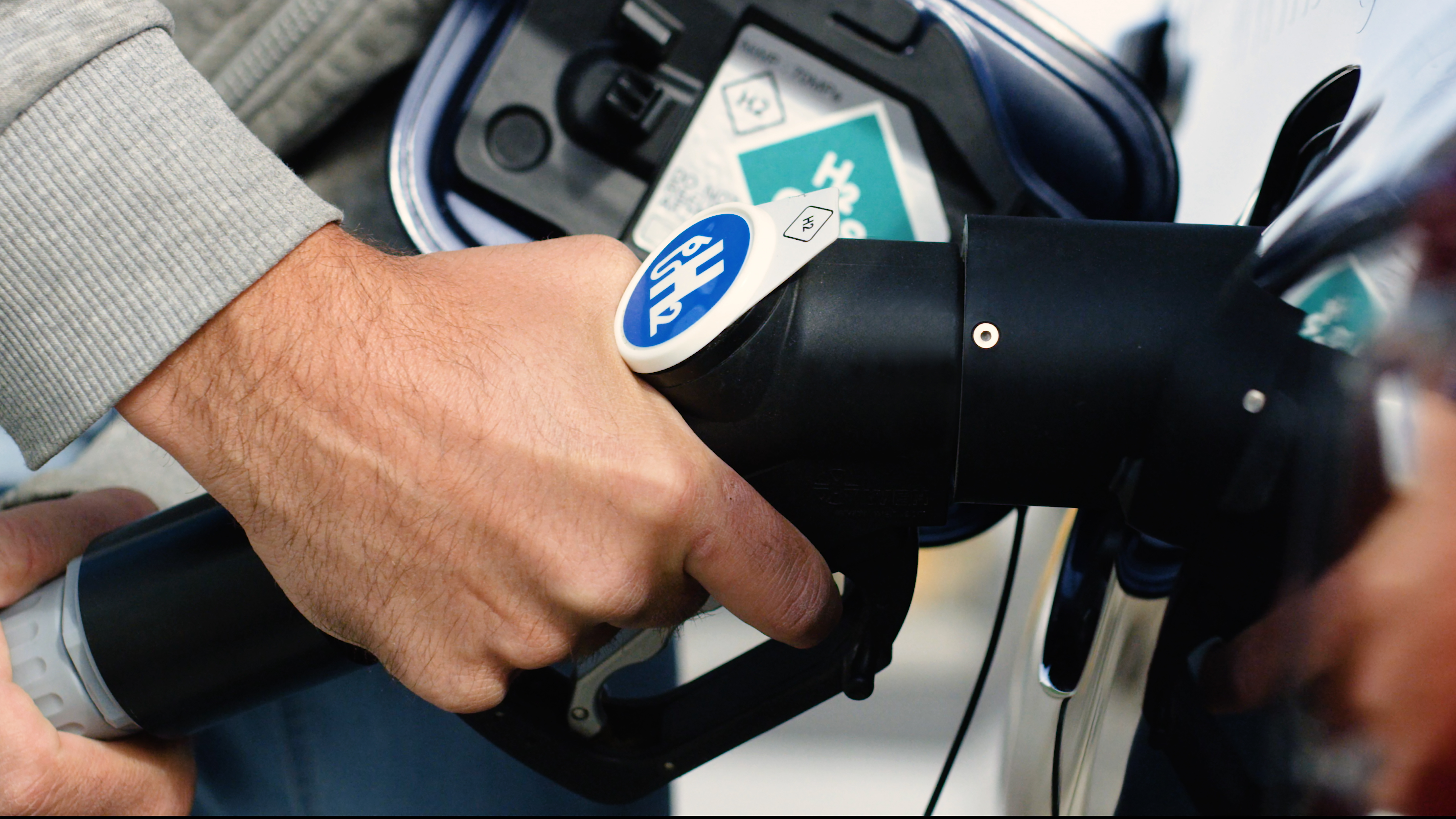 A driver refills the hydrogen fuel for their vehicle.