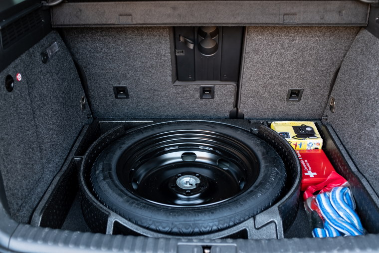 A spare tyre in place under the boot lining of a vehicle.