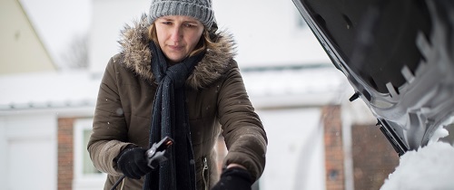 Woman jump starting car in the snow