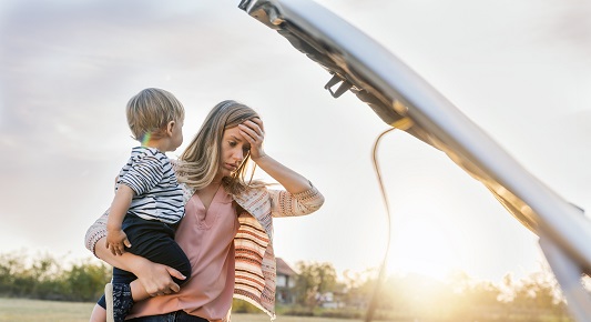 Woman with child looking under car bonnet